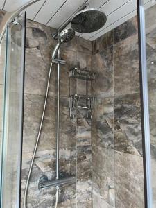 a shower in a bathroom with a stone wall at Chapel Park Studio in Lemington