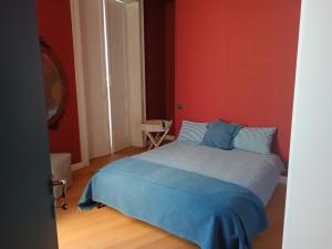 sypialnia z łóżkiem z niebieską pościelą i czerwonymi ścianami w obiekcie Vicodeifiori w mieście Acireale