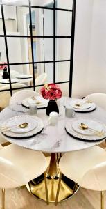 a white table with white plates and flowers on it at Eurto Stay in Mandaue City