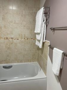 uma casa de banho com banheira e toalhas brancas em LanEnd House em Whiston