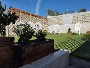 a group of white chairs sitting in a yard at Casa Rural "La Muela de Alarilla" in Alarilla