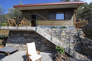 a house built on a stone wall with a staircase at Camera di Molly in Leivi