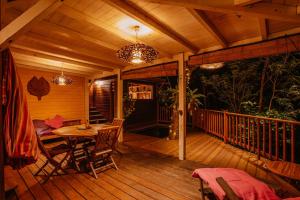 drewniany taras ze stołem i krzesłami w obiekcie Au Jardin Des Colibris Ecolodge&Spa w mieście Deshaies