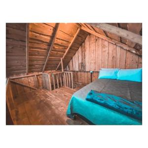 1 dormitorio con 1 cama en un ático de madera en Cabaña Alas de Sable Providencia, en Providencia