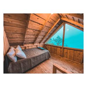 Bett in einem Zimmer mit einem großen Fenster in der Unterkunft Cabaña Alas de Sable Providencia in Providencia