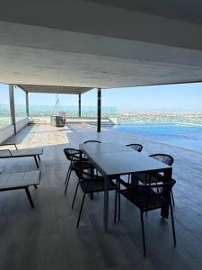 un comedor con mesa y sillas y el océano en Lujoso departamento en Monterrey, en Monterrey