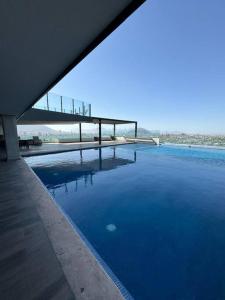 a large pool of blue water next to a bridge at Lujoso departamento en Monterrey in Monterrey