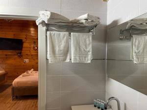 a bathroom with two towels hanging on a wall at Pnina BaMarom in Sifsufa