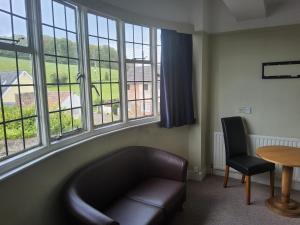 a living room with a couch and a table and windows at The Washford Station Inn, in Washford