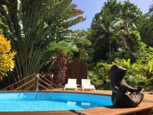 a statue of a seal sitting next to a pool at Au Jardin Des Colibris Ecolodge&Spa in Deshaies