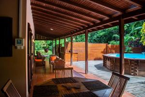 德赛Au Jardin Des Colibris Ecolodge&Spa的带游泳池、桌椅的露台