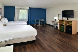 a hotel room with a bed and a desk and a tv at Spark By Hilton Dallas Market Center in Dallas
