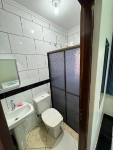 a bathroom with a white toilet and a sink at Hotel 15 de Julho in Foz do Iguaçu