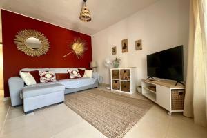 a living room with a couch and a flat screen tv at Casa Dorada Puerto del Carmen in Puerto del Carmen