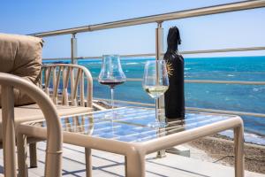 uma mesa com copos de vinho e uma garrafa na varanda em Costa Del Sol em Durrës