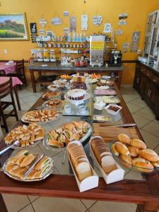 a table with many plates of sandwiches and bread at Hotel Clima da Serra in Cunha