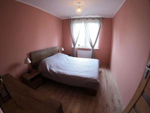 a bedroom with a white bed and a window at Apartament Bażantów in Katowice