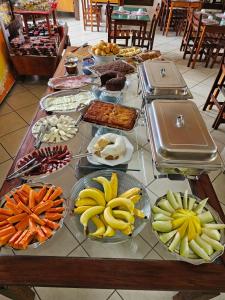 a table topped with plates of food and fruit at Hotel Clima da Serra in Cunha