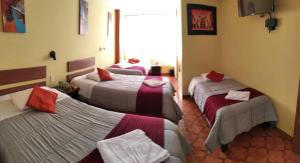 a room with three beds in a room at Hospedaje Del Carmen in Machu Picchu