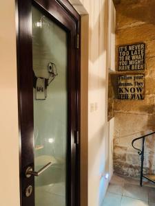 una puerta de cristal con un letrero junto a una pared en Authentic House of Character, en Birgu