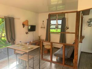 a room with a desk and a table and a chair at Fare lei , bungalow en toute simplicité in Uturoa