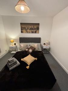 a bedroom with a large bed with a black blanket at City Centre Flat with Free Parking in Newport