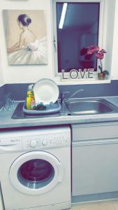 a kitchen with a washing machine and a sink at City Centre Flat with Free Parking in Newport