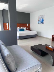 ein Wohnzimmer mit einem Bett und einem Sofa in der Unterkunft Best Western Minatitlan in Minatitlán