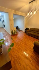 a living room with a couch and a wooden floor at CASTELLARES LA PUEBLA APARTAMENT in Ayacucho