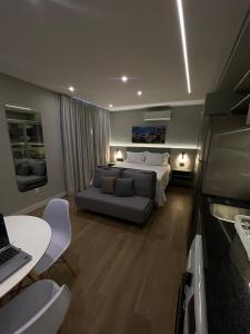 サンパウロにあるIguatemi Stay B - PREMIUM location, MODERN and NEW space, Affordableのベッドとソファとテーブルのある寝室