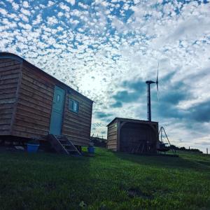 un cobertizo y una casa y un molino de viento en un campo en Cwt y Mynydd, en Chester