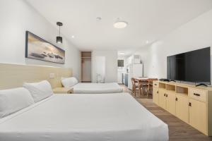 a hotel room with two beds and a flat screen tv at Saga Resort in Wasaga Beach