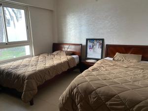 um quarto com 2 camas e uma janela em cozy apprtr em Agadir