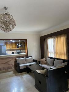 uma sala de estar com dois sofás e um lustre em cozy apprtr em Agadir