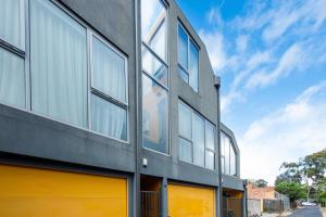 a building with glass windows on the side of it at Sunlit Serenity in the Heart of Collingwood in Melbourne