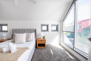 a bedroom with a bed and a large window at Sunlit Serenity in the Heart of Collingwood in Melbourne
