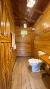 a bathroom with a toilet in a wooden cabin at Bioma EcoLodge in Iranduba