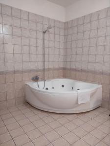 a white bath tub in a tiled bathroom at Le Residenze di Niso in Syracuse