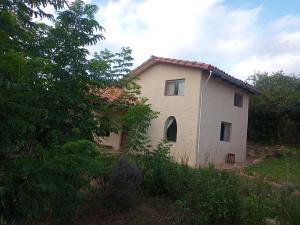a small white house with a window in a field at Casa Loto in Samaipata