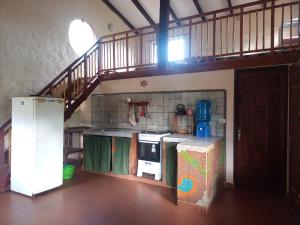 cocina con escalera y nevera en Casa Loto, en Samaipata