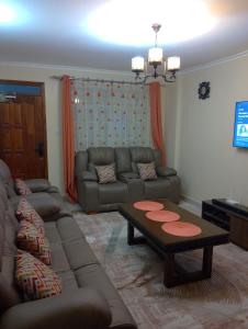a living room with a couch and a coffee table at Jamhuri Executive Suites in Nairobi