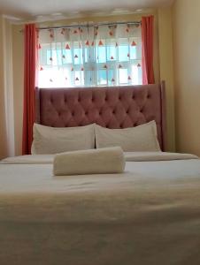 a bedroom with a large bed with a window at Jamhuri Executive Suites in Nairobi