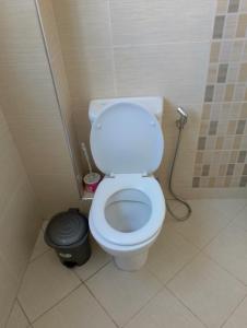 a bathroom with a toilet and a black trash can at Jamhuri Executive Suites in Nairobi