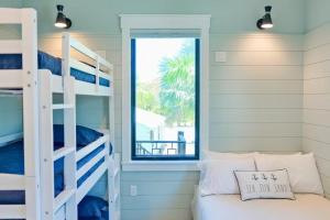 a bedroom with bunk beds and a window at Tropical Gulf View Estate - Anna Maria, FL in Anna Maria