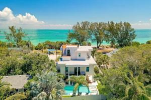 an aerial view of a house with the ocean in the background at Tropical Gulf View Estate - Anna Maria, FL in Anna Maria