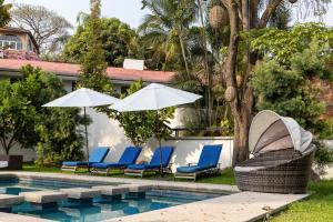 a group of chairs and umbrellas next to a pool at New Family Home with Pool Jacuzzi & Fronton in Cuernavaca