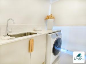 a kitchen with a sink and a washing machine at Pembrey Perfection in Cowes
