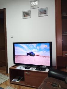 TV de pantalla plana en la parte superior de una mesa en Apartman Mladenovic Center, free parking&wifi en Vranje