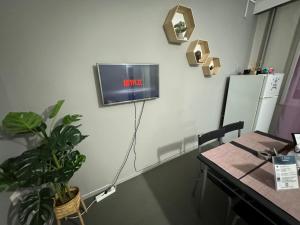 a room with a table and a tv on the wall at Best minimal studio in Xanthi - myHomee in Xanthi