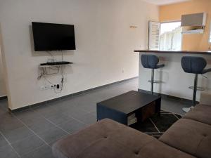 een woonkamer met een bank en een flatscreen-tv bij Le T3 de l'Ouest in Saint-Laurent du Maroni
